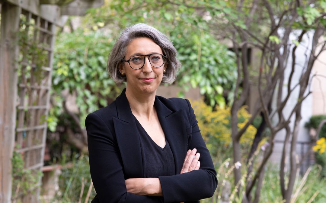 Portrait of Dr. Samira Mubareka in a navy blue blazer, arms folded against a backdrop of trees